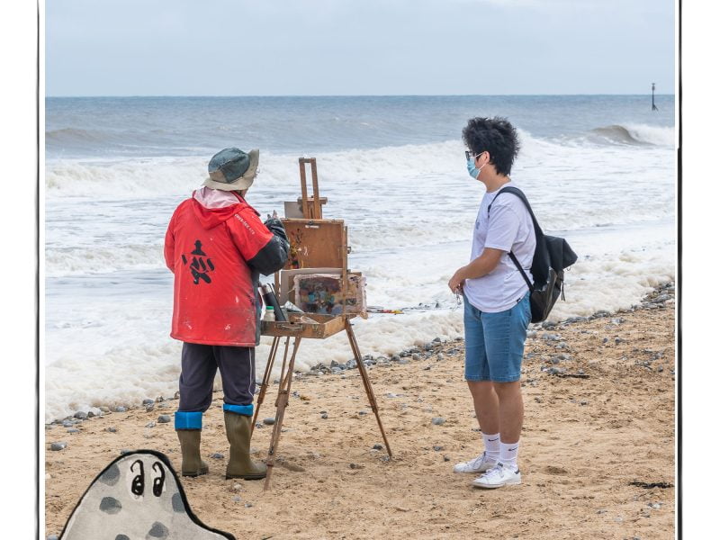Image of an artist on the beach in Norfolk, UK, framed with a sketch line and overlaid with a hand drawn image of a seal
