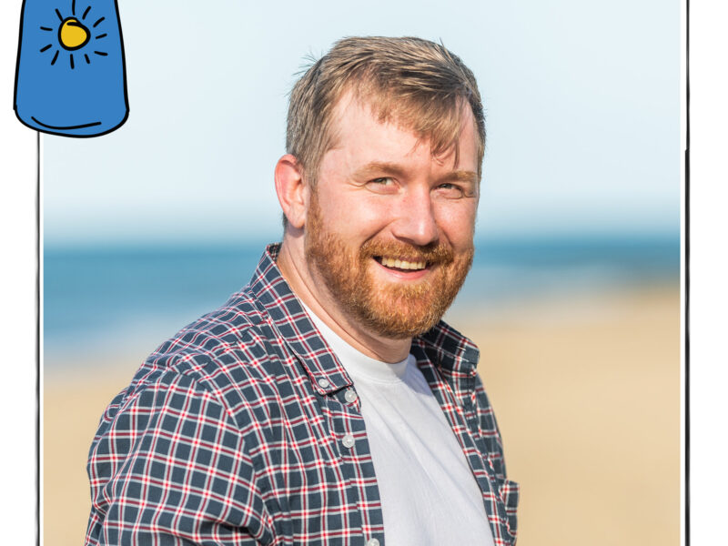 Image of a smiling man in a checked shirt against the background of a beach. It is framed by a sketch line and overlaid with a hand drawn image of a bottle of sun cream